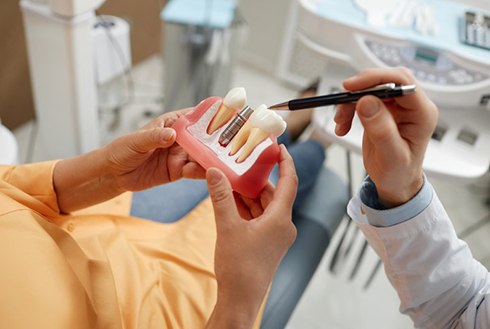 a dentist explaining how dental implants work to a patient