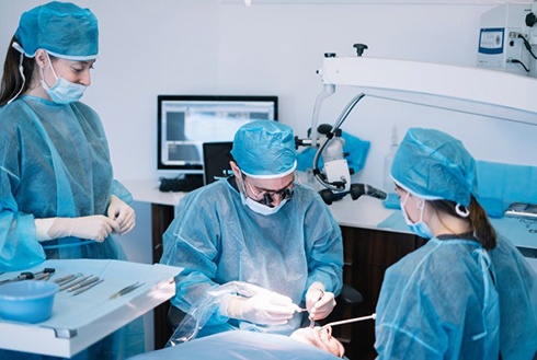 an oral surgeon performing the dental implant surgery