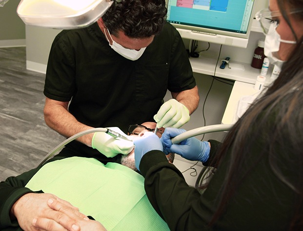 Dentist and dental team member treating a patient
