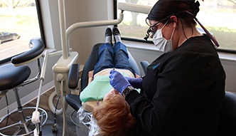 Dental team member giving a patient a teeth cleaning