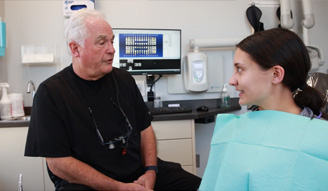 Doctor Walton talking to young woman in dental chair