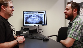 Doctor Bell sitting across desk from a dental patient