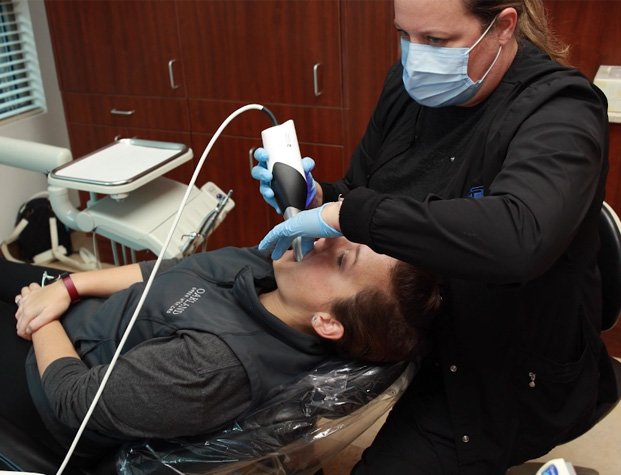 Dental team member taking digital impressions of a patient