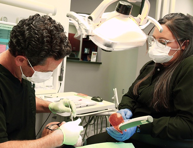 Dentist and assistant treating a dental patient