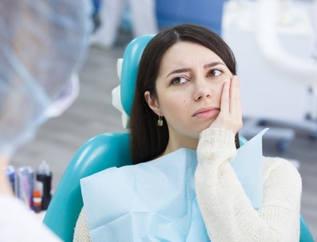 Dental patient holding the side of her face in pain