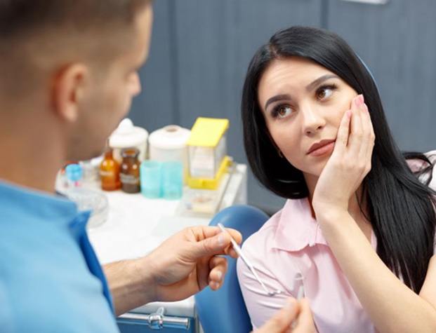 Woman with toothache visiting her dentist