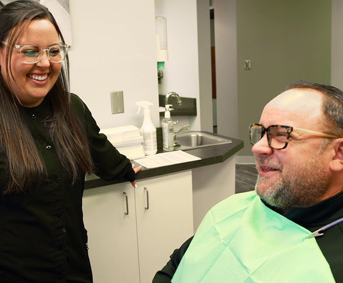 Dental team member laughing with a patient before sedation dentistry