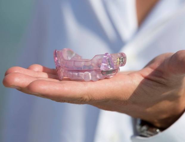 Dentist holding light purple occlusal splints