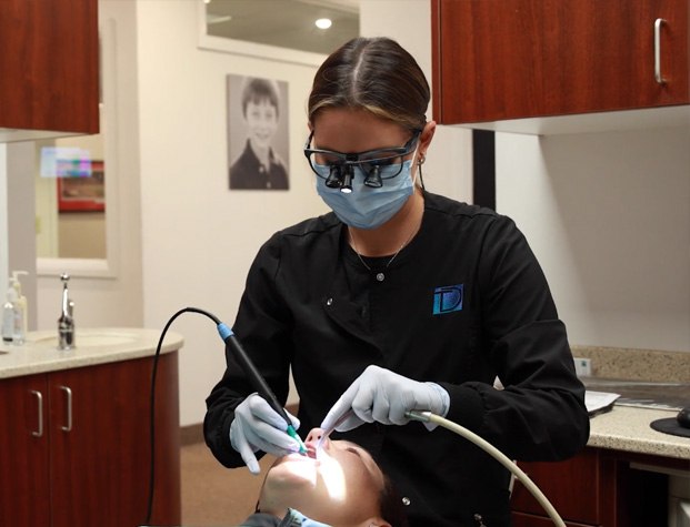 Dental team member giving a patient a professional teeth cleaning