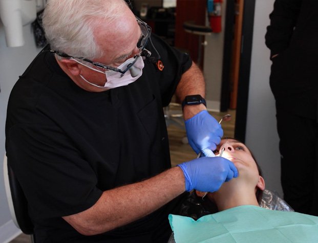 Doctor Walton performing oral cancer screening on dental patient