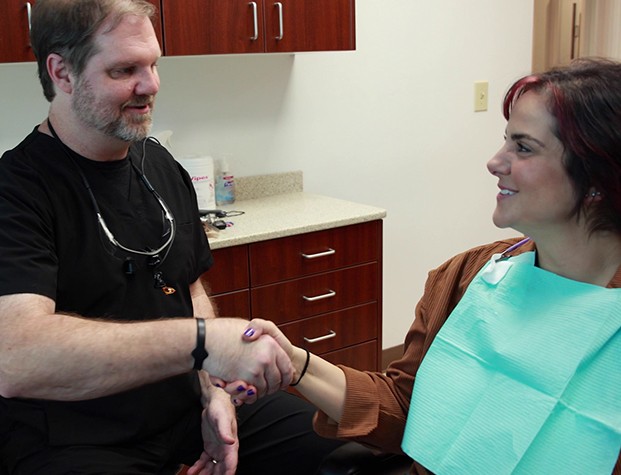 Doctor Bell shaking hands with patient in dental chair