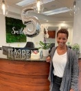 Smiling woman at dental office front desk