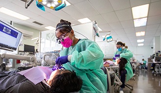 Several dental hygienists performing teeth cleanings