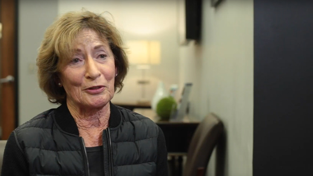 Older woman in black jacket sitting in dental office