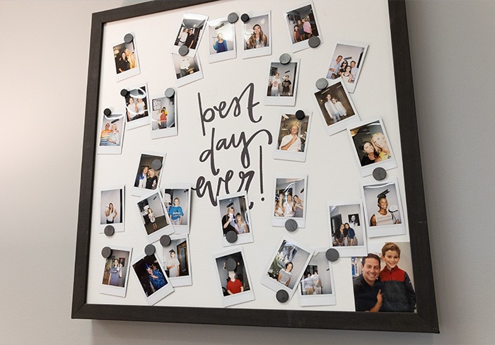 Board on wall featuring several photos of children dental patients